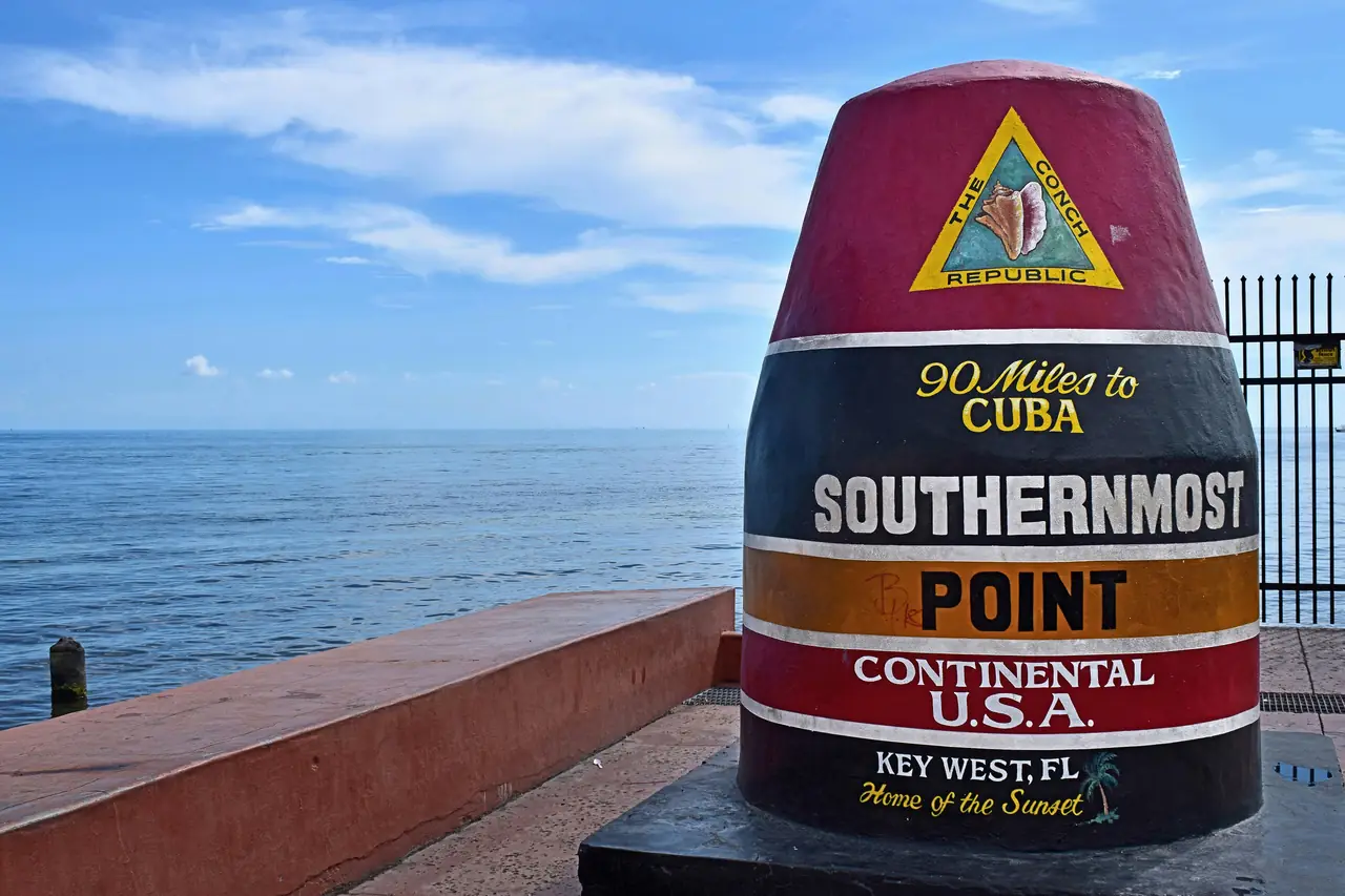 The Southernmost Point buoy in Key West, Florida, painted "90 Miles to Cuba", beside the open sea