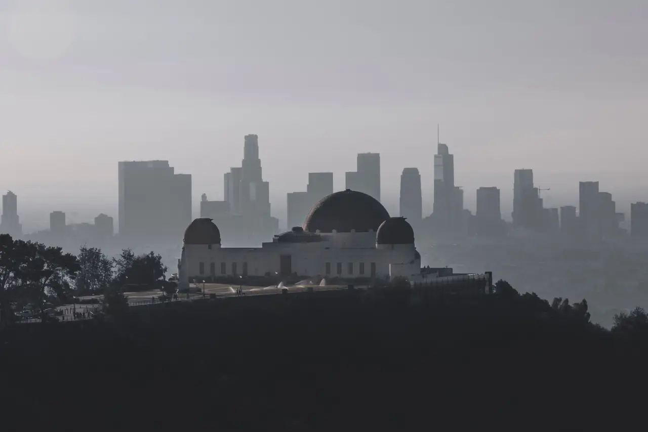 Griffith Observatory on Mount Hollywood silhouetted against the hazy downtown Los Angeles skyline