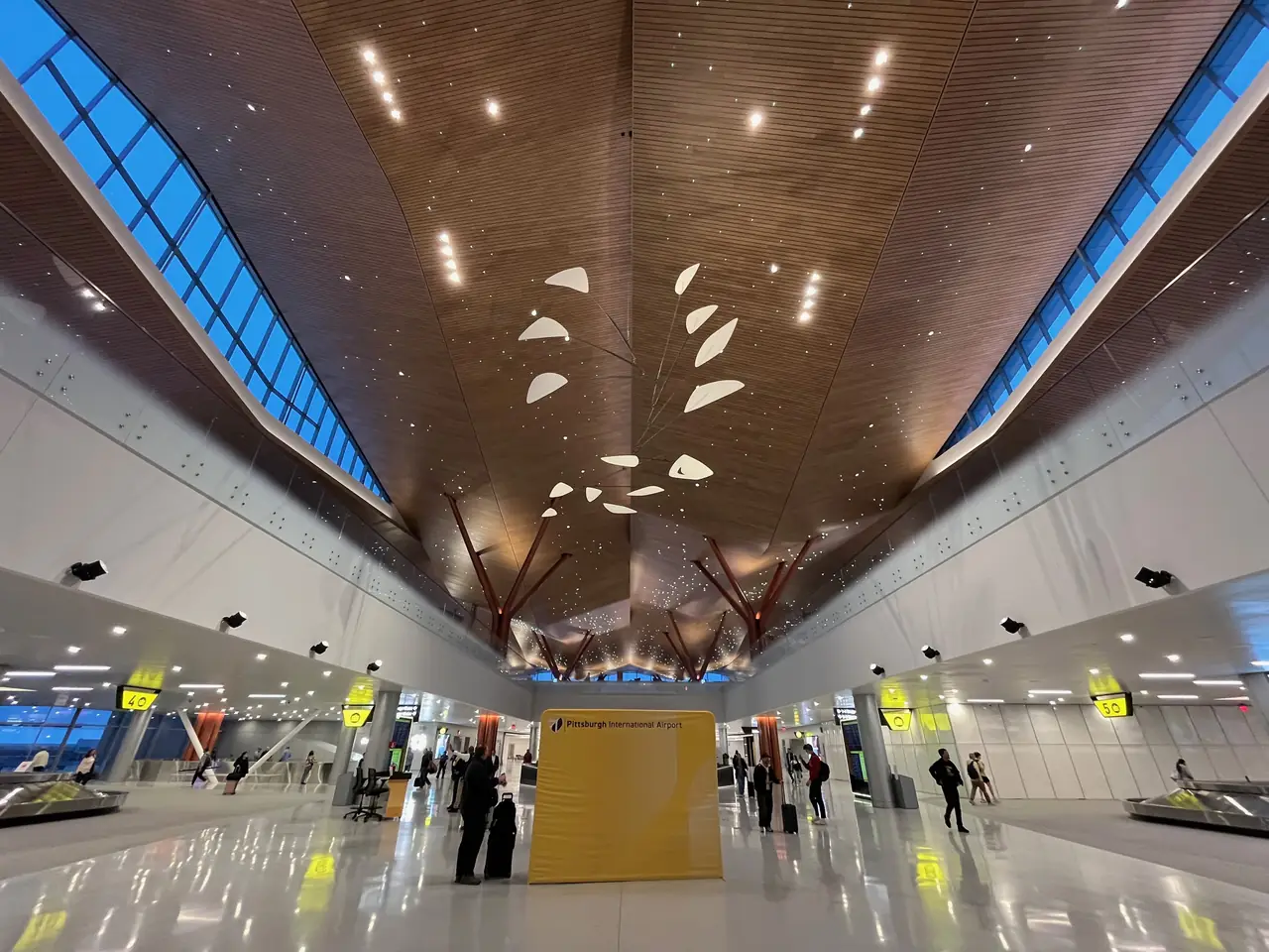 Inside Pittsburgh International Airport's new terminal: a wood-slatted ceiling, long skylights and a hanging mobile over the main hall