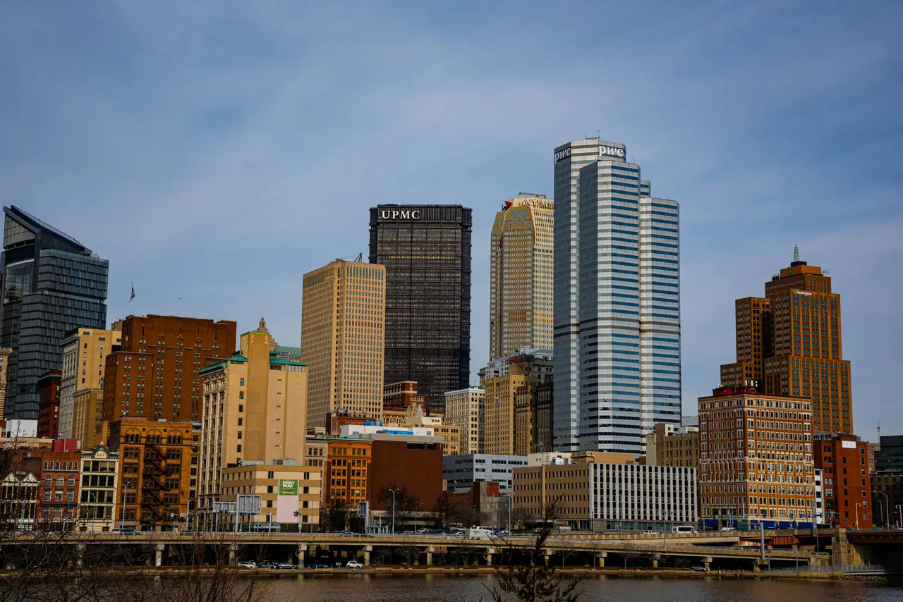 Downtown Pittsburgh's skyline across the river on a clear day, with the UPMC sign atop the U.S. Steel Tower at center
