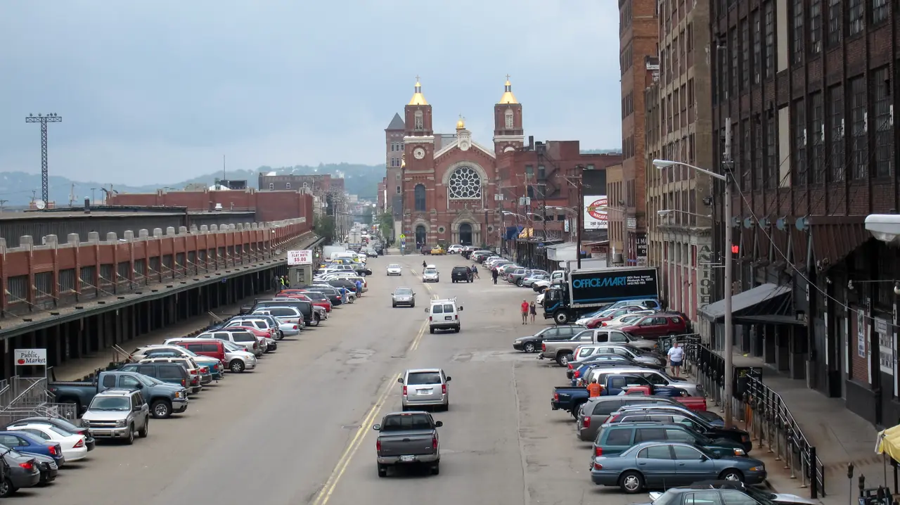 Smallman Street in Pittsburgh's Strip District, lined by the old produce terminal and warehouses, with St. Stanislaus Kostka Church's twin towers at the end